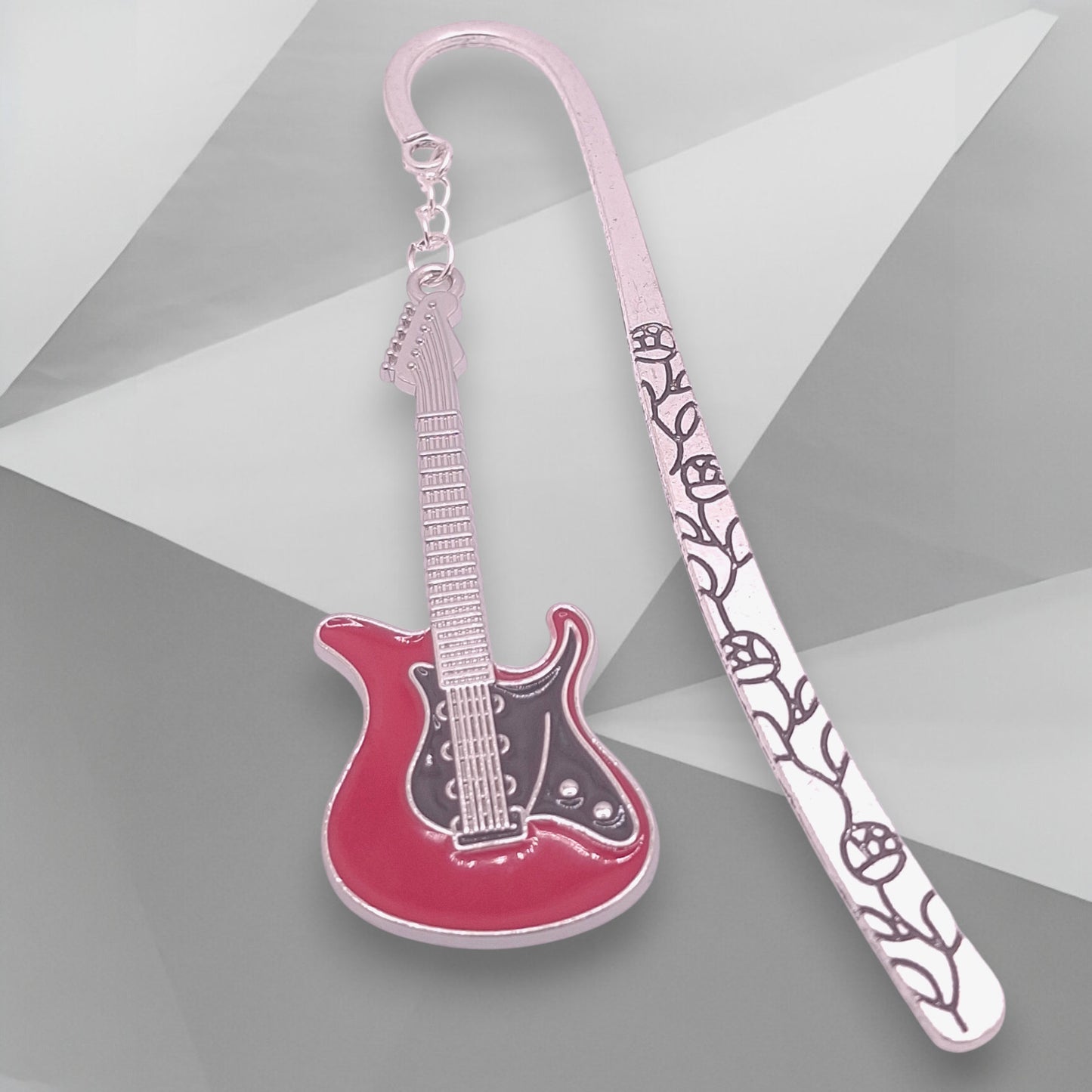 Red and black electric guitar on a floral-patterned bookmark on a gray background